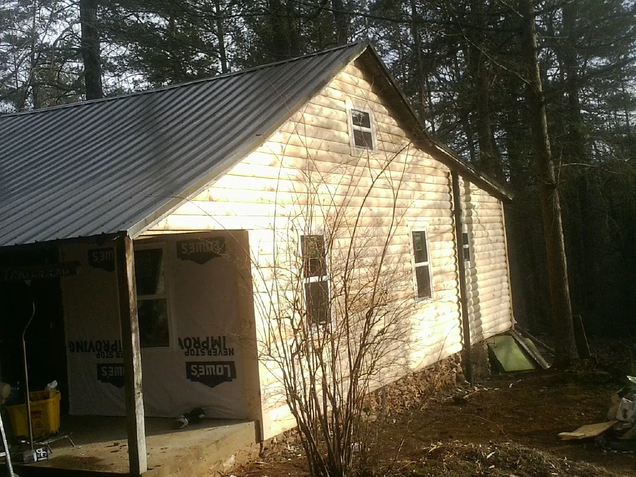 Log siding gable end under a dark metal roof edge in Geneva